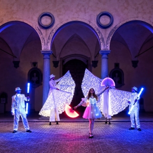 Artisti con costumi luminosi per accogliere gli ospiti durante un'inaugurazione