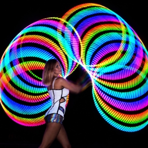 Artista con hula hoop luminoso durante uno spettacolo per eventi privati