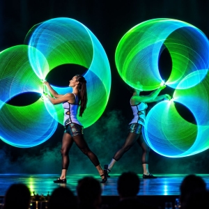 Artista con hula hoop luminoso durante uno spettacolo LED per cena di gala
